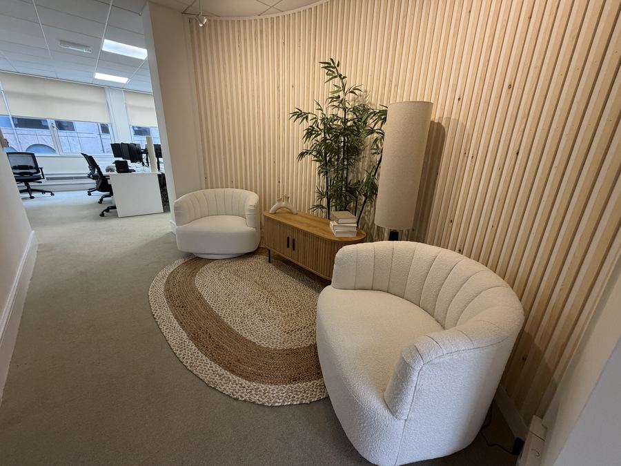 Fitted-out London office reception with panelled wall and seating